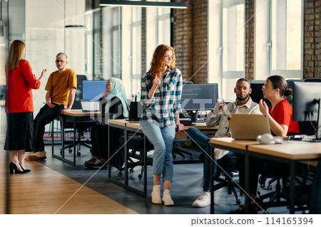 A diverse group of young business individuals congregates in a modern startup coworking center, embodying collaborative innovation and a dynamic atmosphere 114165394