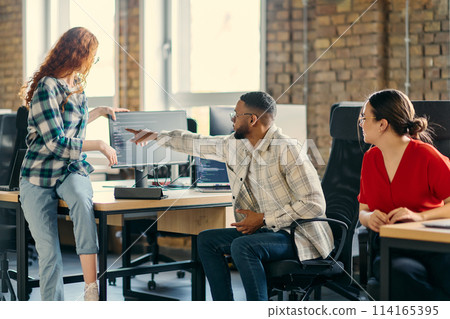 A diverse group of young business individuals congregates in a modern startup coworking center, embodying collaborative innovation and a dynamic atmosphere 114165395