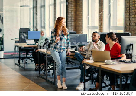 A diverse group of young business individuals congregates in a modern startup coworking center, embodying collaborative innovation and a dynamic atmosphere 114165397