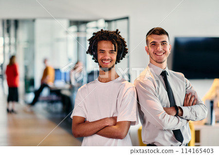 A group of colleagues, including an African American businessman and a young leader in a shirt and tie, pose together in a modern coworking center office, representing a dynamic blend of 114165403
