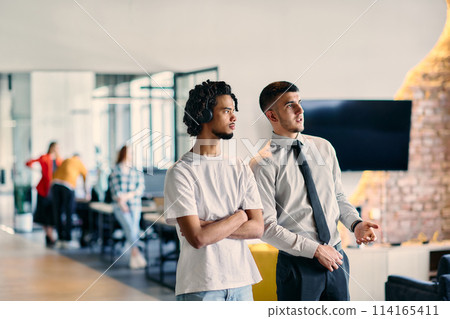 A group of colleagues, including an African American businessman and a young leader in a shirt and tie, pose together in a modern coworking center office, representing a dynamic blend of A group of colleagues, including an African American businessman and a young leader in a shirt and tie, pose together in a modern coworking center office, representing a dynamic blend of 114165411