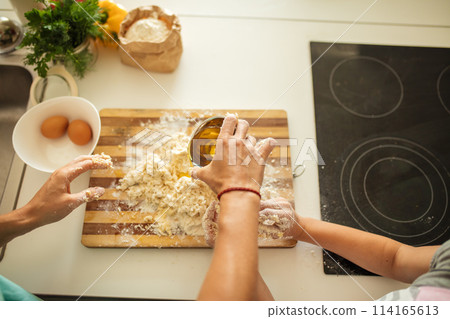 Top view of woman and little daughter making cookies while cooking on kitchen. 114165613