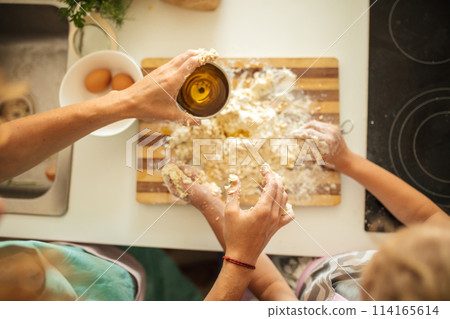 Top view of woman and little daughter making cookies while cooking on kitchen. 114165614