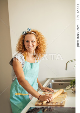 Beautiful young mom and her cute little daughter are playing and smiling while baking in kitchen at home 114165644