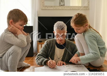 Gray-haired grandmother plays with her little grandchildren Gray-haired grandmother plays with her little grandchildren 114165851