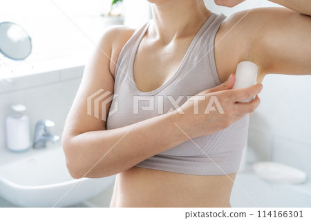 Closeup woman applying natural crystal alum deodorant in modern bathroom. Eco friendly natural beauty and hygiene cosmetics. Zero waste, sustainable, alternative body care concept. Selective focus 114166301
