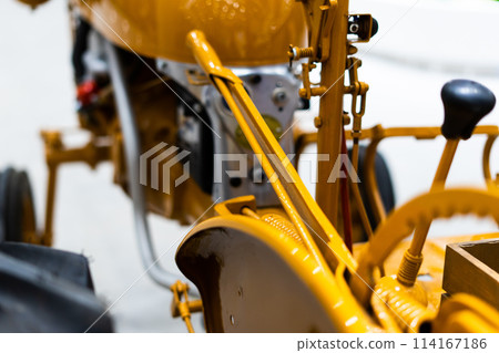 Detail of a small tractor with yellow construction tracks, Caterpillar Ten Detail of a small tractor with yellow construction tracks, Caterpillar Ten 114167186