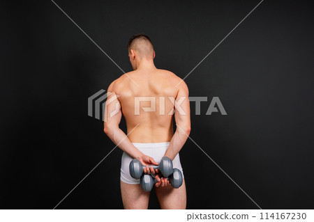 Man with a pumped-up body with dumbbells in his hands white panties exercise Man with a pumped-up body with dumbbells in his hands white panties exercise 114167230