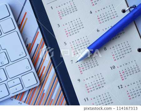 Graph, keyboard, notebook and calendar on a table 114167313