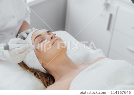 Beautician uses RF lifting to improve skin tone and tighten contour face. This safe and effective method uses radio frequency waves to stimulate collagen and elastin, improving skin structure and 114167646