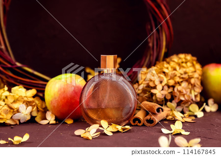 perfume bottle, apples, cinnamon and dry hydrangea flowers on brown background. Honey autumn cozy aroma, Eau de toilette. Unbranded transparent glass perfume bottle for branding and label, mockup. perfume bottle, apples, cinnamon and dry hydrangea flowers on brown background. Honey autumn cozy aroma, Eau de toilette. Unbranded transparent glass perfume bottle for branding and label, mockup. 114167845