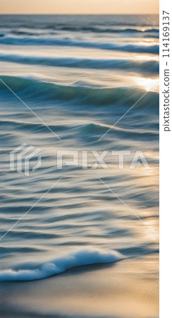 Smoothly blurred sky over a sun-kissed calm sea, golden sands of a tranquil beach in the foreground Smoothly blurred sky over a sun-kissed calm sea, golden sands of a tranquil beach in the foreground 114169137