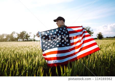 Man hold waving american USA flag. Patriot raise national american flag. Independence Day, 4th July. 114169362