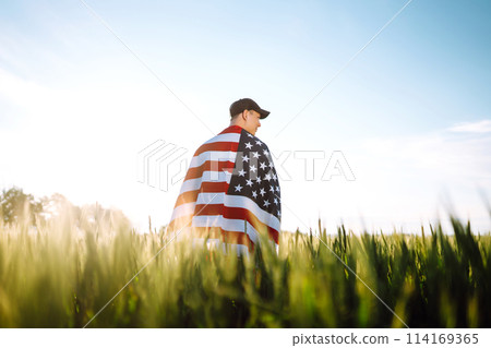 Man hold waving american USA flag. Patriot raise national american flag. Independence Day, 4th July. Man hold waving american USA flag. Patriot raise national american flag. Independence Day, 4th July. 114169365