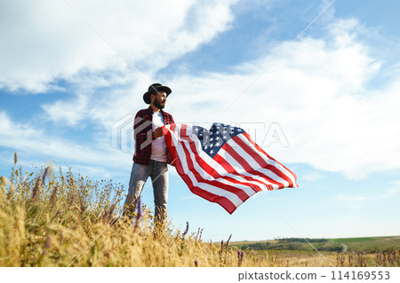 4th of July. American Flag.Patriotic holiday. Traveler with the flag of America. Beautiful sunset light. American style. 4th of July. American Flag.Patriotic holiday. Traveler with the flag of America. Beautiful sunset light. American style. 114169553
