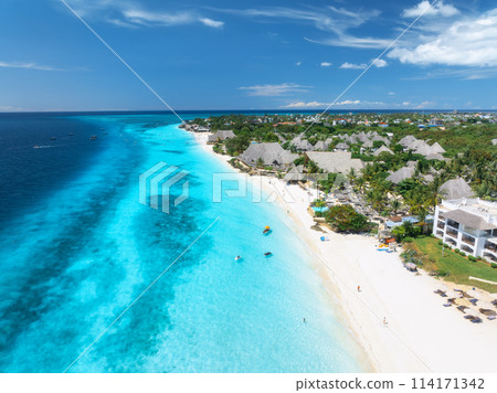 Aerial view of sandy beach, blue sea, bungalows, palms, umbrellas 114171342