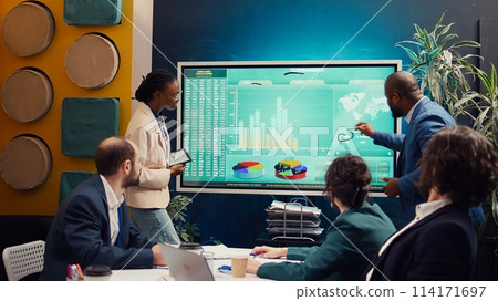 Work team assembling in a brainstorming meeting to look for sources of funding, allocating available resources to ensure goals accomplishment. Training to increase financial potential. Camera B. 114171697