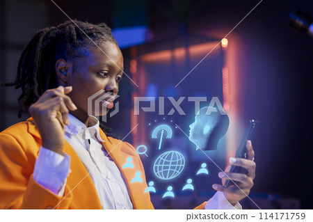 African american woman at home using mobile phone, interacting with artificial intelligence assistant using AR. Person working with augmented reality, solving tasks on internet helped by AI 114171759