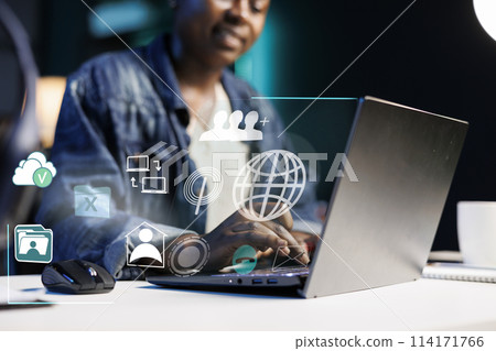African american woman working from home on laptop, online connectivity concept. Remote employee using augmented reality technology to visualize notebook software functions 114171766