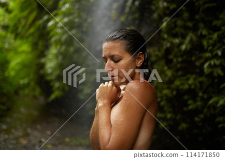 Portrait of a young slender nude woman near an incredibly beautiful waterfall in a cliff in the jungle on the popular island of Bali. Portrait of a young slender nude woman near an incredibly beautiful waterfall in a cliff in the jungle on the popular island of Bali. 114171850