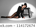 Beautiful woman in retro style in a black bodysuit and a bow in her hair in full length posing on a gray background. Beauty of body and face 114172674