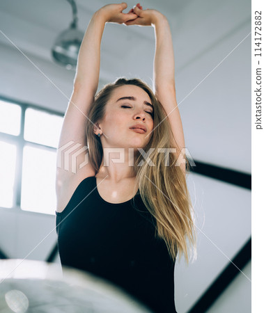 Slim female with closed eyes putting hands up Slim female with closed eyes putting hands up 114172882