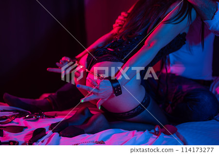 Close-up of a woman's buttocks during role play with a partner. BDSM concept. Close-up of a woman's buttocks during role play with a partner. BDSM concept. 114173277