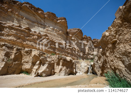 Waterfall cascading through desert canyon in Tamaqzah, Tunisia Waterfall cascading through desert canyon in Tamaqzah, Tunisia 114174627