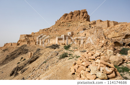 Ancient stone houses and on the mountain slopes in Guermassa region. South Tunisia. Tatouine governorate,Tunisia 114174686