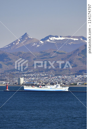 拍攝春天北海道函館市進入函館港的津輕海峽渡輪和白雪皚皚的駒岳風景。 114174797
