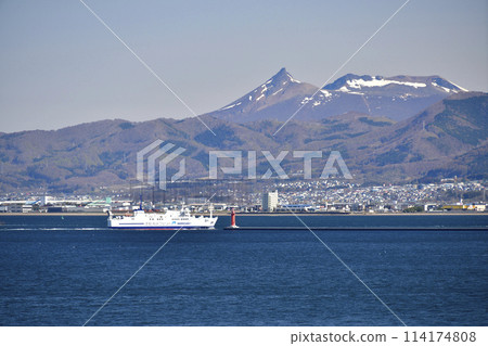 拍攝春天北海道函館市進入函館港的津輕海峽渡輪和白雪皚皚的駒岳風景。 114174808