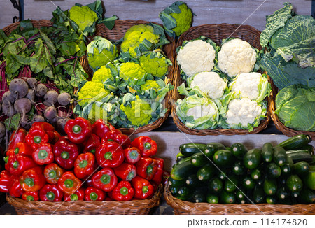 Vegetables in baskets laid out for sale on market stall 114174820
