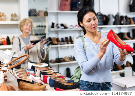 Woman selecting new shoes in shoeshop 114174997