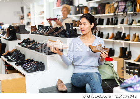Asian woman is going to try on her chosen shoes Asian woman is going to try on her chosen shoes 114175042