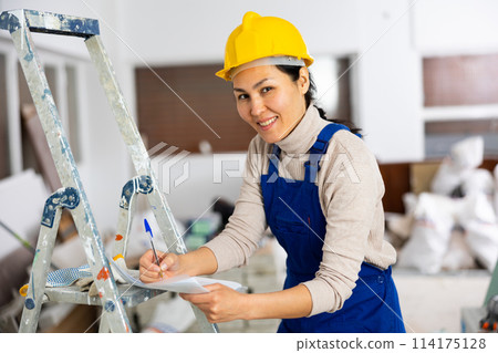 Positive woman builder filling project documentation Positive woman builder filling project documentation 114175128