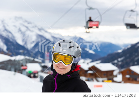 Woman in ski helmet and goggles spending winter holidays in ski resort 114175208