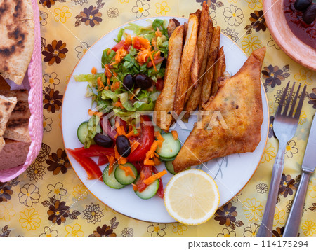 Tunisian brik pie served with vegetable salad 114175294