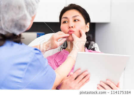 Cosmetologist planning upcoming lip reshaping procedures for female patient Cosmetologist planning upcoming lip reshaping procedures for female patient 114175384