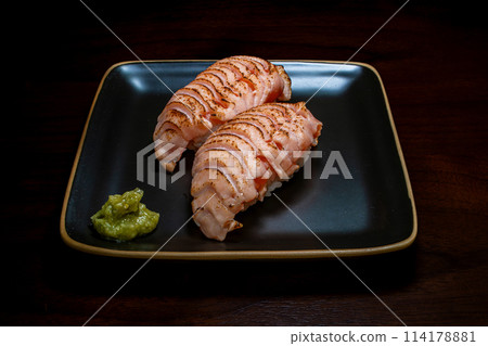 Sushi, nigiri sushi, grilled salmon, black background, overhead view 114178881