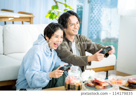 Couple playing games in the living room Couple playing games in the living room 114179835