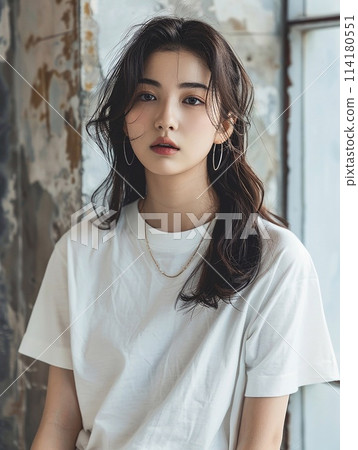 Asian woman in oversized white t-shirt against the backdrop of a vintage cement wall in an old apartment. Asian woman in oversized white t-shirt against the backdrop of a vintage cement wall in an old apartment. 114180551
