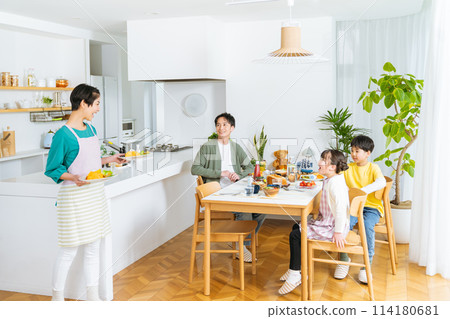 Family of four eating in the dining room 114180681