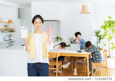 Housewife with a calculator in the dining room 114180732