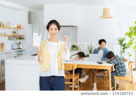 Housewife with a calculator in the dining room 114180733