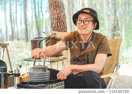 一名男性露營者在露營時使用爐子和水壺燒水和煮咖啡 114180780
