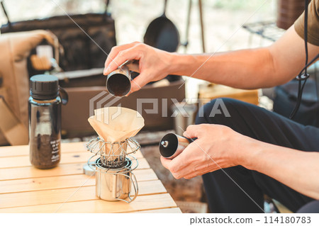 一名男性露營者在露營地用咖啡研磨機煮咖啡的手 114180783