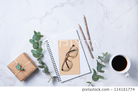 Flat lay with  eucalyptus flower, cup of coffee, glasses,  a pencils, a craft notebook  114181774