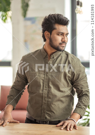 Indian man smiling at camera in his office 114181993