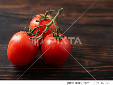 Healthy  food. Fresh aromatic red tomatoes   on a brown wooden background. Macro view 114182070