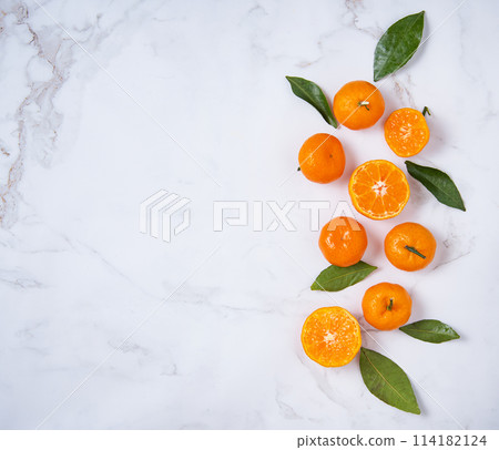 Flat lay sweet  tangerines and green leaves  on a white marble background 114182124